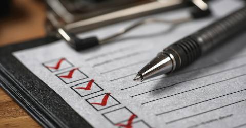 Checklist papier en pen met afgevinke hokjes